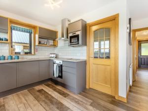 a kitchen with stainless steel appliances and a wooden door at The Larches - Uk46804 in Culbokie