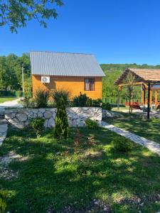 a house with a stone retaining wall and a building at Mtis guli in Bangveti