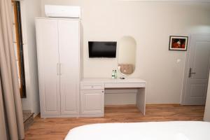 a bedroom with a white desk with a tv on a wall at Hotel Dimora 1927 in Tirana