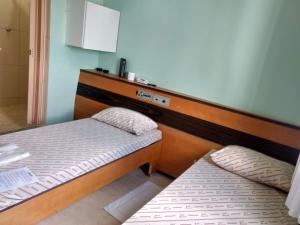 two twin beds in a room with at Hotel metrosul Ltda in São Paulo