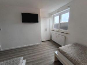 a room with two beds and a television on the wall at Ferienwohnung-Heide-3 in Walsrode