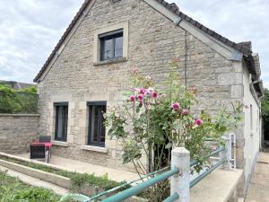 a stone house with pink flowers in front of it at Le calme dans 100M2 in Condé-sur-Sarthe +4 photos