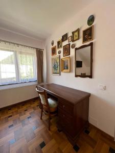 a home office with a desk and a mirror at Casa de sub Hășmaș in Bălan