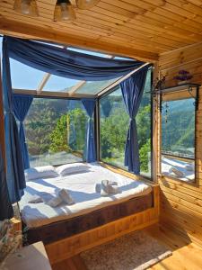a bedroom with a bed and a large window at Hill House Merisi in Merisi