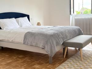 a bedroom with a bed and a chair and a window at Le calme dans 100M2 in Condé-sur-Sarthe