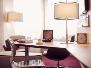 a desk with a lamp and a chair at Mercure Limoges Centre in Limoges