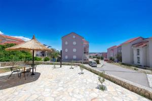 a patio with a table and an umbrella at Apartments Silvia in Novalja