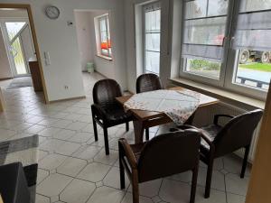 a dining room with a table and chairs and windows at Anjas Ferienwohnung Buchenrod in Flieden