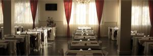 a room full of tables with white at Hotel La Chiesaccia in Crespellano