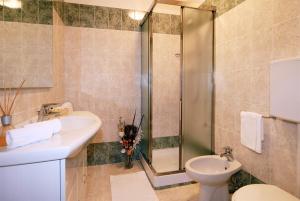 a bathroom with a shower and a toilet and a sink at Hotel La Chiesaccia in Crespellano