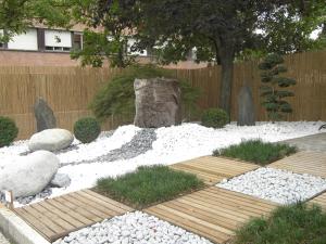 a garden with white rocks and a tree at Hotel La Chiesaccia in Crespellano
