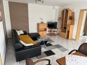 a living room with a couch and a tv at Anjas Ferienwohnung Buchenrod in Flieden