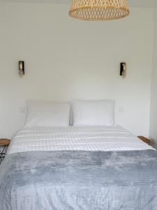 a bedroom with a white bed with a white comforter at Le calme dans 100M2 in Condé-sur-Sarthe