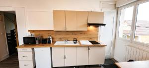 a kitchen with a sink and a microwave at Parc Exposition, Zénith, Stade Sotteville Rouen - Linge & Ménage Inclus in Sotteville-lès-Rouen