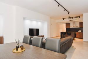 a dining room and living room with a table and chairs at BH - Three Bedroom Apartments in Sliema