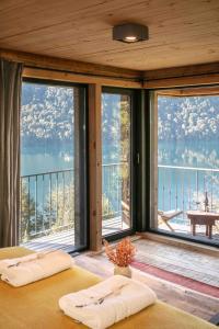 a bedroom with two beds in a room with large windows at Hermoso Eco Lodge in San Martín de los Andes