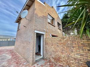 a brick building with a sign on the side of it at Sunesta Cottage in Gqeberha