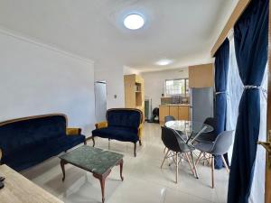 a living room with blue chairs and a table at Sunesta Cottage in Gqeberha