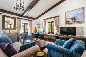 a living room with two couches and a tv at Corinthian Blue Retreat in Katakoúli