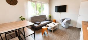 a living room with a couch and a table at Parc Exposition, Zénith, Stade Sotteville Rouen - Linge & Ménage Inclus in Sotteville-lès-Rouen