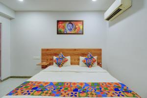 a bedroom with a bed with a painting on the wall at FabHotel Vaishnavi Classic in Secunderabad +24 photos