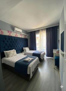 a hotel room with two beds and a window at Akman City Hotel in Kuşadası +67 photos