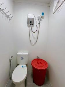 a bathroom with a toilet and a red trash can at Marianne's Guest House in New Agutaya +35 photos