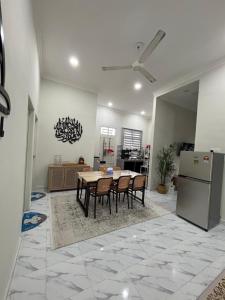 a kitchen and dining room with a table and a refrigerator at D Teratak Homestay in Marang +3 photos