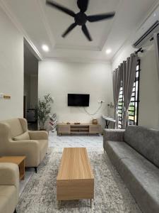 a living room with a couch and a ceiling fan at D Teratak Homestay in Marang