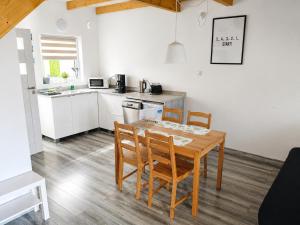 a kitchen with a wooden table and chairs in a kitchen at Domki 7 Houses Rewal in Rewal +17 photos
