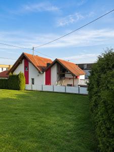 a house with a red roof and a green yard at All Homes Apartments Bad Schallerbach in Bad Schallerbach