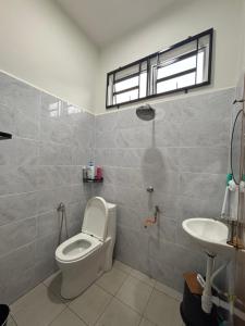 a bathroom with a toilet and a sink at D Teratak Homestay in Marang