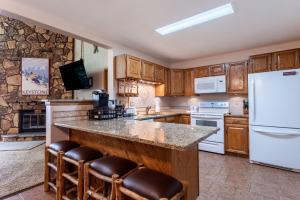 a kitchen with wooden cabinets and a white refrigerator at Snowdance Manor #405 : 2 in Keystone