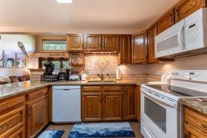 a kitchen with wooden cabinets and white appliances at Snowdance Manor #405 : 2 in Keystone +36 photos