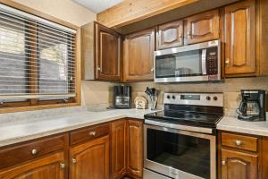a kitchen with wooden cabinets and a microwave at Timber Ridge Retreat in Bellaire