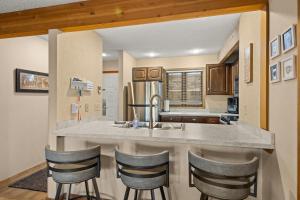 a kitchen with a sink and a counter with bar stools at Timber Ridge Retreat in Bellaire