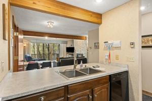 a kitchen with a sink and a living room at Timber Ridge Retreat in Bellaire