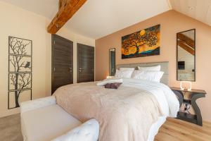 a bedroom with a large white bed with a couch at Le Moulin de mes garçons in Alby