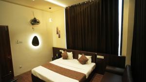 a hotel room with a bed and a window at Hotel Crystal Rajkot in Rajkot