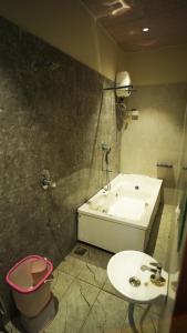 a bathroom with a sink and a tub and a toilet at Hotel Crystal Rajkot in Rajkot