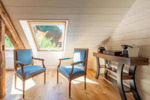 two chairs and a desk in a room with a window at Le Moulin de mes garçons in Alby