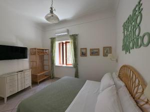 a bedroom with a bed and a flat screen tv at 2Steps Capri - central holiday house in Capri