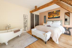 a bedroom with a large bed and a bath tub at Le Moulin de mes garçons in Alby