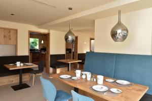 a dining room with a wooden table and blue chairs at Chalet Anna in Marlengo