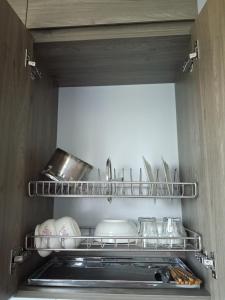 a kitchen with dishes and utensils on a shelf at Homestay Vân Canh Hà Nội in Ðại Tự