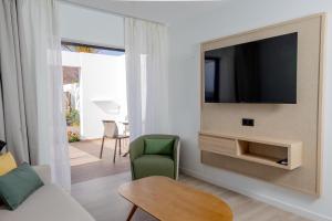 a living room with a tv on a wall at Relaxia Lanzasur Club - Aqualava Water Park in Playa Blanca