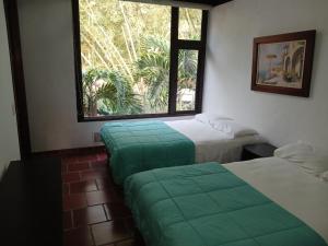a room with two beds and a window at Hotel campestre terrazas y sol in La Vega
