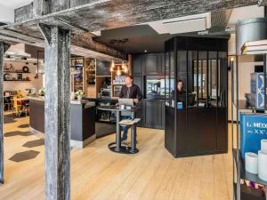 two men standing at a counter in a restaurant at ibis Styles Dinan Centre Ville in Dinan