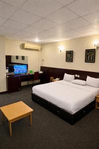 a hotel room with a large bed and a desk at Royalbirds Motel in Akure +24 photos