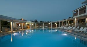 a view of a pool at night with lounge chairs at Arty Grand Hotel in Olympia